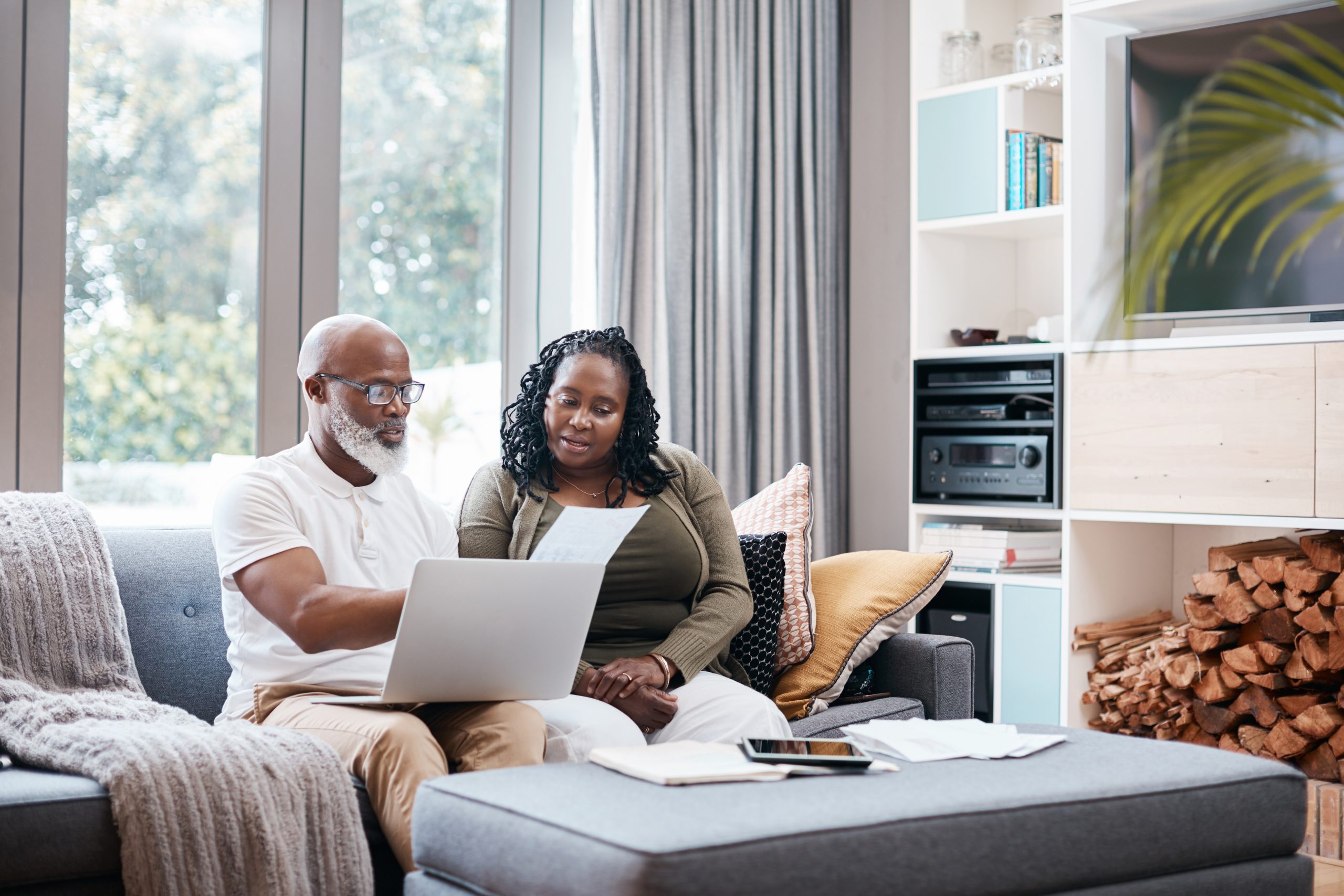 A woman and man sit on a couch looking over papers and a laptop. When applying for disability benefits, you’ll need to sort out the differences between SSDI and SSI.