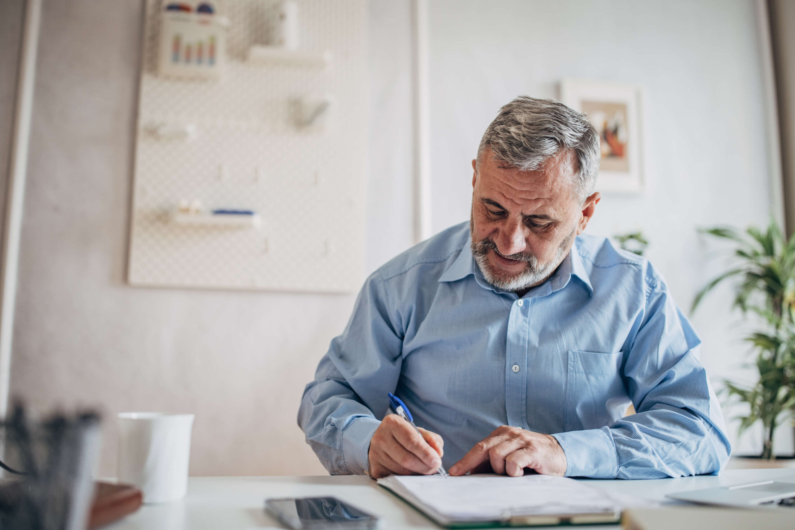 A man sits at a table writing notes. Applying for disability benefits or appealing a denial, Barnes disability lawyers can help.