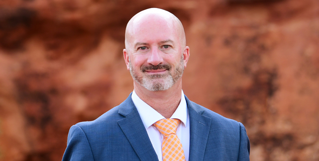 Portrait of Matt Ormsby, a Utah SSD attorney at Barnes Disability Advocates focusing on disability hearings, in front of red rocks.