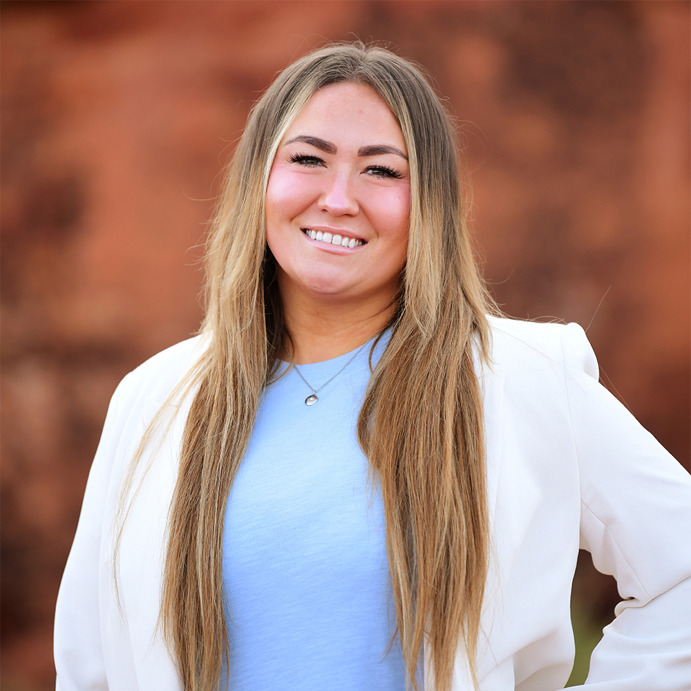 Allina Reier, Social Security Disability legal assistant at Barnes Disability Advocates, in front of red rocks in Utah.