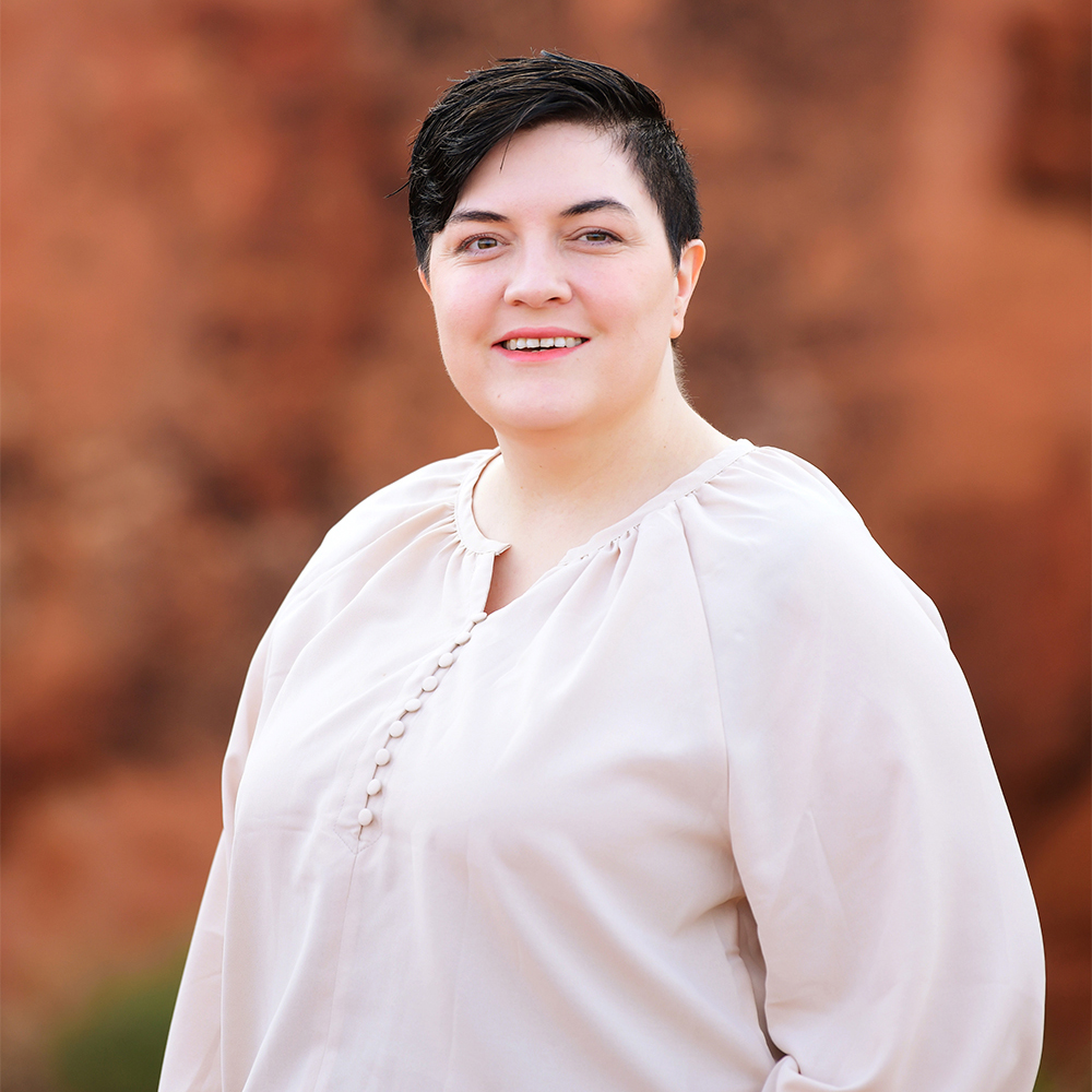 Brianna McFadden, Social Security Disability legal assistant at Barnes Disability Advocates, in front of red rocks in Utah.