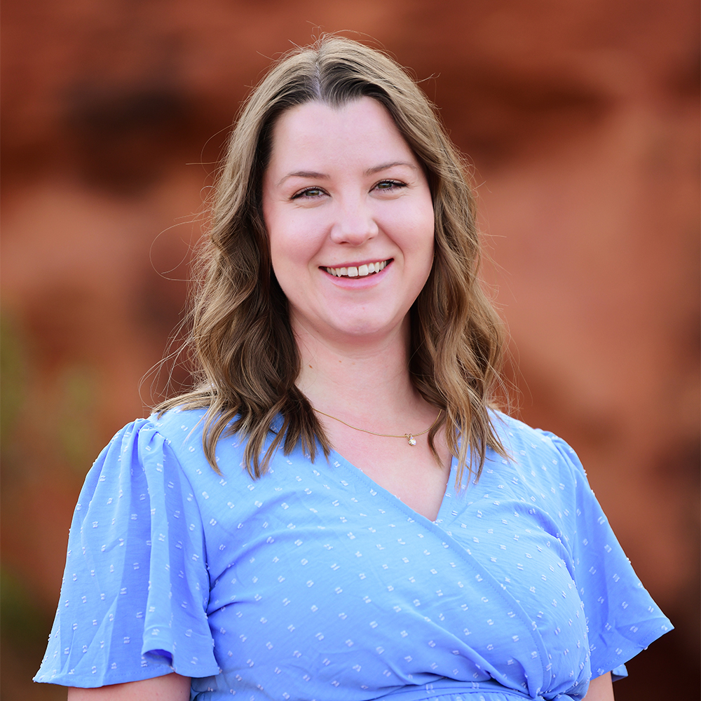 Rachel Milligan, disability claims legal assistant at Barnes Disability Advocates, in front of red rocks in Utah.