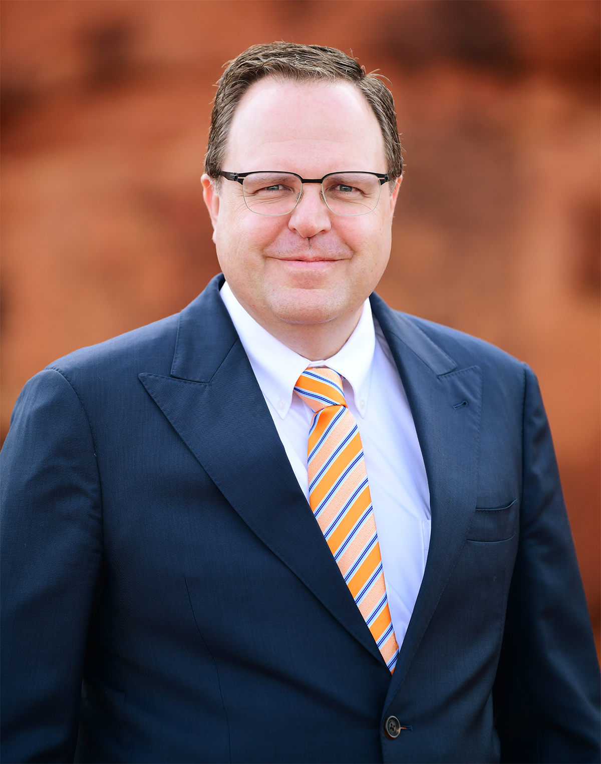 Portrait of Jay Barnes, Utah disability lawyer, founder and president of Barnes Disability Advocates, in front of red rocks.